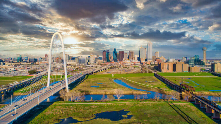 Dallas skyline featuring iconic buildings against a clear blue sky, showcasing the city's modern architecture and urban landscape.