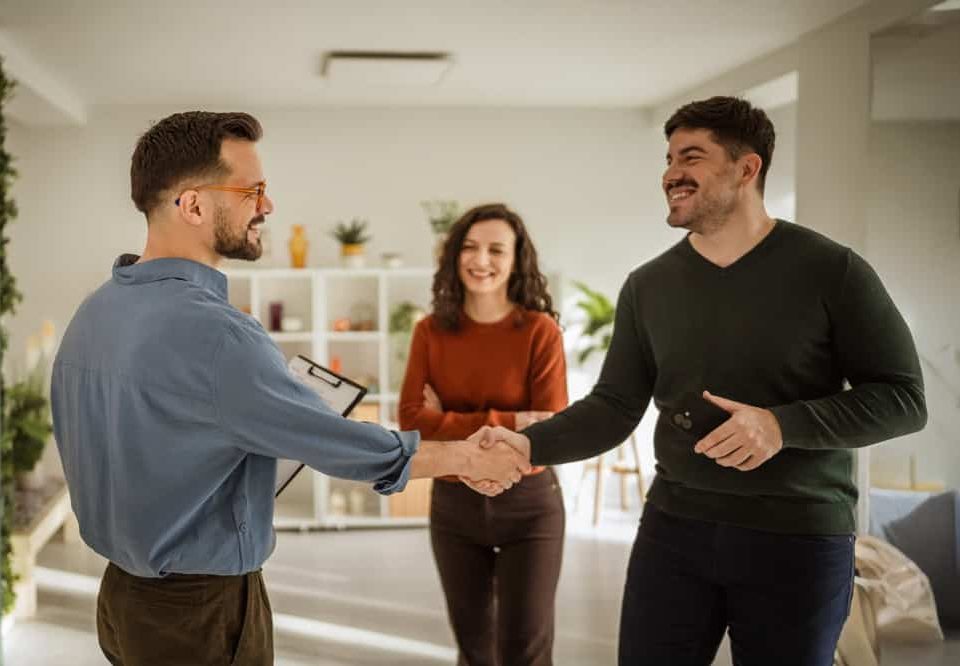 Two Men Shaking Hands In A Modern Office Setting, Symbolizing A Business Agreement Or Partnership